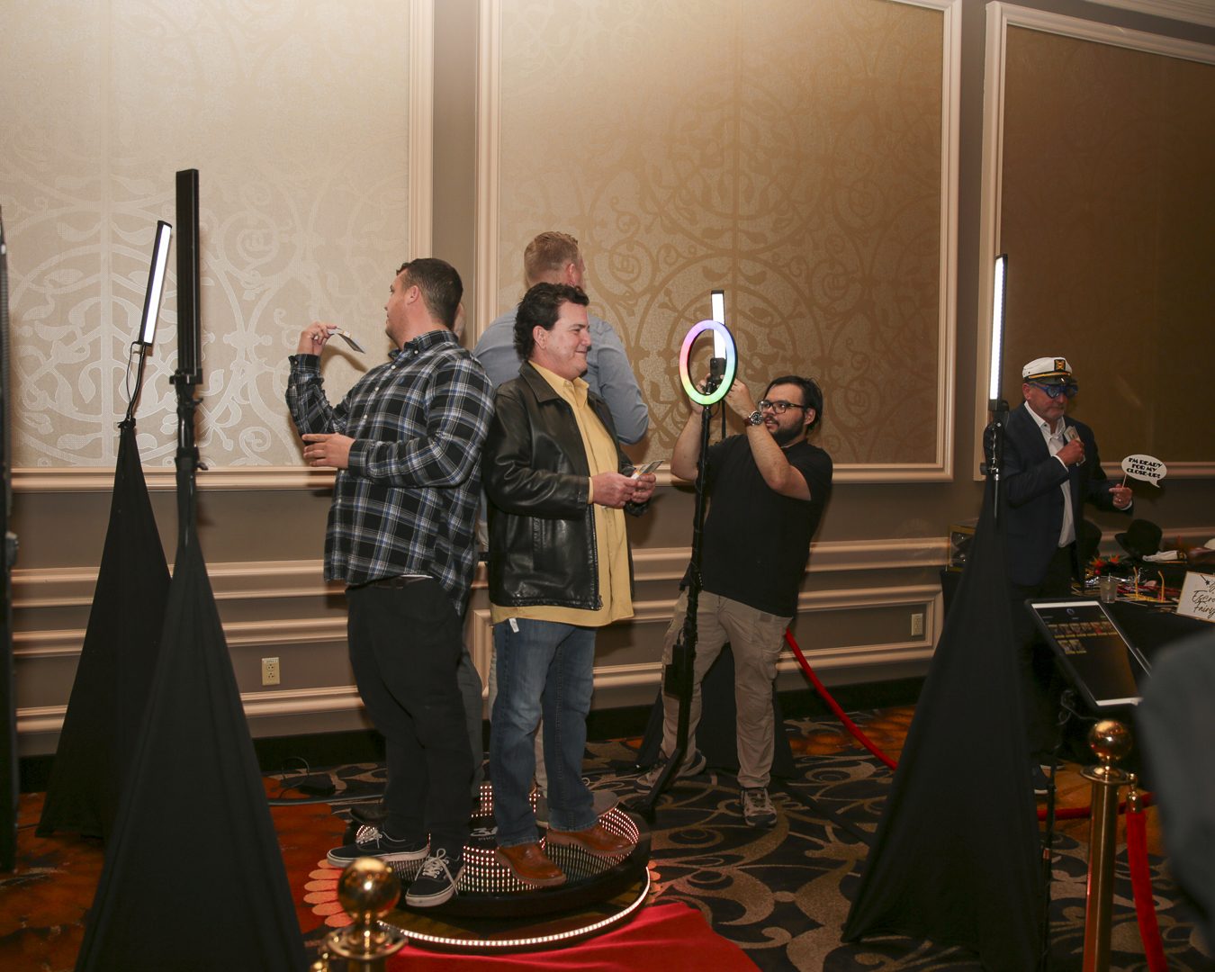 Guests on 360 photo booth platform at corporate event with ring light and LED screens