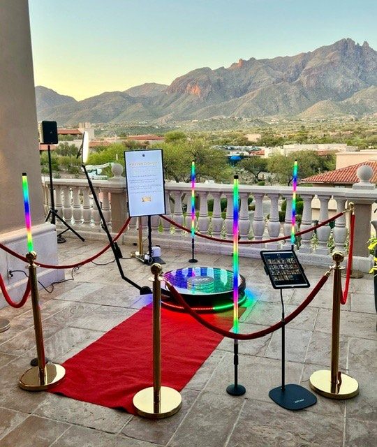 360 booth setup with LED light poles and red carpet at luxury resort patio overlooking mountains at sunset